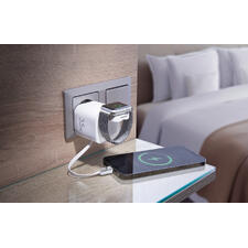 Chargeur rapide de voyage - Rare et incroyablement pratique : l’adaptateur de charge 4-en-1 avec câble USB-C intégré et station de charge Qi. Chargeur rapide chargeant simultanément un smartphone et une smartwatch dans un environnement hôtelier.