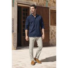 Chemise en jean et seersucker Oliver Spencer      Homme portant une chemise en jean seersucker Oliver Spencer bleue et un pantalon clair, se tenant à l'extérieur.