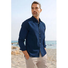 Chemise en jean et seersucker Oliver Spencer      Homme en chemise en jeans Seersucker foncé assis sur la plage.