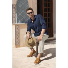 Chemise en jean et seersucker Oliver Spencer      Homme portant des lunettes de soleil en chemise en jean seersucker Oliver Spencer bleue, assis sur un banc.