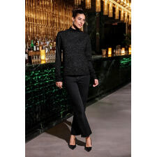 Pull glamour Junghans 1954 Pull-over glamour noir pour femmes, debout dans un bar élégant.