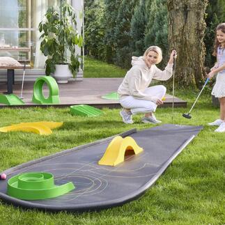 Femme et enfant jouant au mini-golf sur un parcours portable.