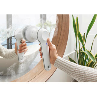 Brosse de nettoyage à main rechargeable utilisée pour nettoyer un miroir.
