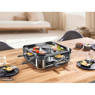 Gril à raclette avec extraction de fumée intégrée sur une table dressée.
