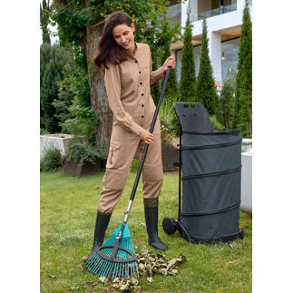 Femme travaillant avec un râteau dans le jardin.