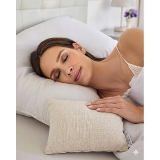 Une femme dort paisiblement avec un petit coussin anti-moustiques sur un plus grand oreiller.