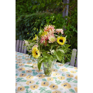 Table dressée avec une nappe aquarelle et un bouquet de fleurs.