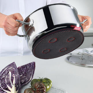 Main tenant un sous-plat magnétique sous une casserole.