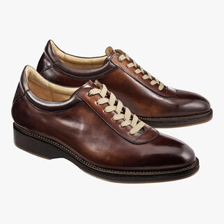 Deux Cordwainer Edelsneakers en marron sur fond clair.