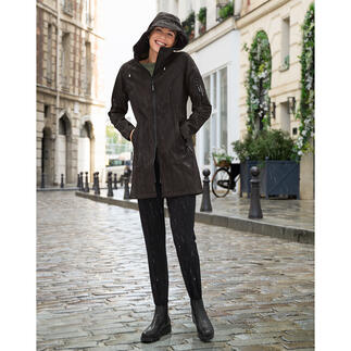 Femme en imperméable noir sur une rue pluvieuse