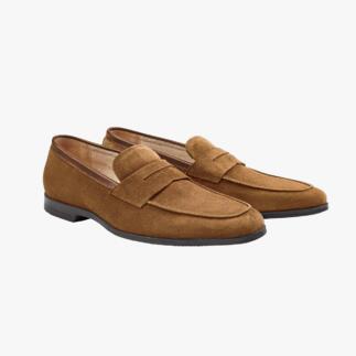 Mocassins en daim marron, vue latérale sur fond clair.