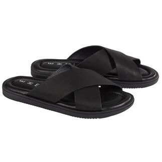 Une paire de pantoufles en cuir noir sur fond blanc