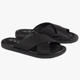 Une paire de pantoufles en cuir noir sur fond blanc