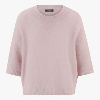 Un pull rose doux et court à manches de Junghans, design minimaliste.