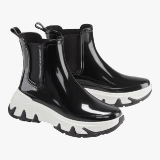 Bottes Chelsea noires avec des semelles blanches, placées par paires sur fond blanc.