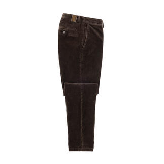 Pantalon en velours brun foncé posé sur une table avec une poche ouverte.
