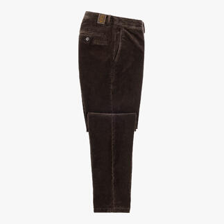 Pantalon en velours brun foncé posé sur une table avec une poche ouverte.