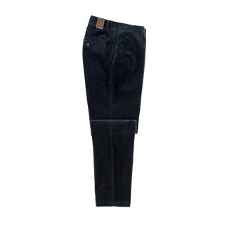 Pantalon en velours noir posé sur une table avec des poches ouvertes.
