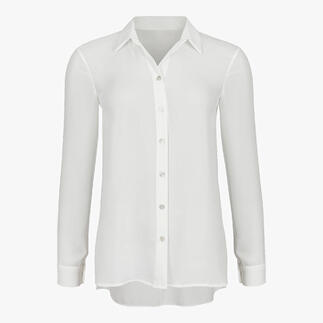 Blouse blanche avec rangée de boutons, longue coupe et manches élégantes.
