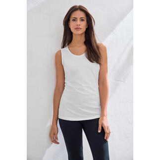 Débardeur blanc en Swiss Cotton sur un mur clair.
