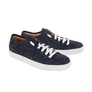 Une paire de sneakers tressées bleues avec des lacets blancs sur un fond blanc.
