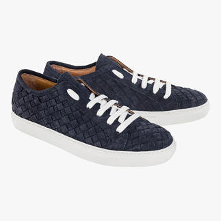 Une paire de sneakers tressées bleues avec des lacets blancs sur un fond blanc.