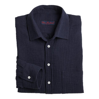 Chemise en mousseline navy bien pliée sur un fond blanc.
