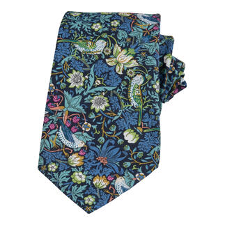 Cravate bleue avec motifs d'oiseaux et dessins floraux sur fond foncé.