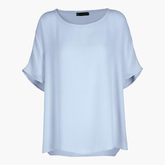 T-shirt blouse bleu ciel avec une coupe ample et des manches courtes sur un fond neutre.