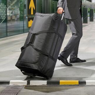 Un sac de voyage ultraléger XXL noir est poussé par un homme en costume.