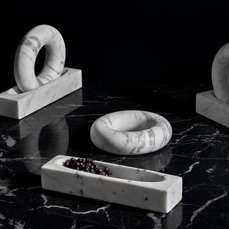 Trois mortiers en marbre de différentes formes sur une surface sombre.