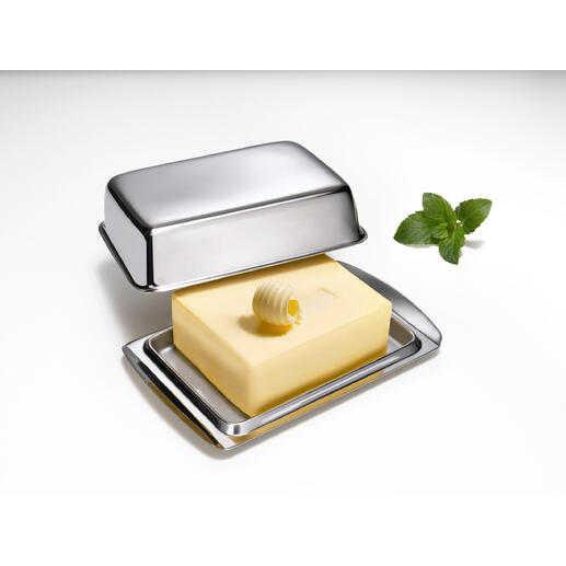 Beurrier en inox avec couvercle et morceau de beurre sur un fond blanc