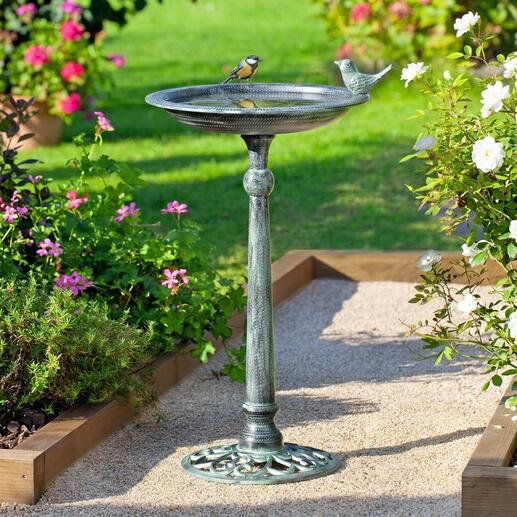 Bain d'oiseau victorien avec un oiseau dans un jardin en fleurs