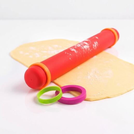 Rouleau à pâtisserie Vario en silicone rouge avec anneaux amovibles sur une feuille de pâte.