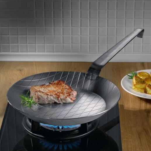 Poêle en fer forgé avec steak sur le feu.