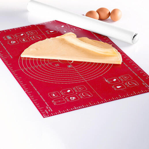 Tapis en silicone pour étaler avec de la pâte et des œufs sur fond blanc.