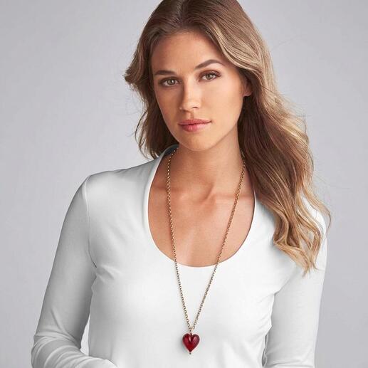 Femme portant un pendentif en cœur Murano autour du cou.