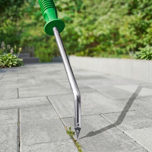 Grattoir à joints avec coupe en V sur un chemin pavé.