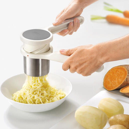 Mains utilisant le presse-purée Helix™ pour écraser des pommes de terre.