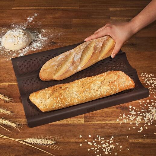 Tapis de cuisson en silicone pour baguette avec deux baguettes fraîchement cuites.