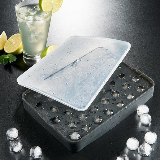 Moule à boules de glace avec des glaçons congelés et une boisson.