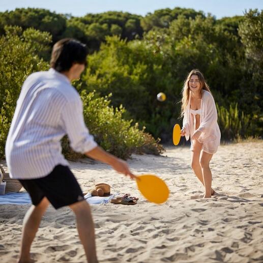Couple à la plage jouant à un jeu de beachball fait main