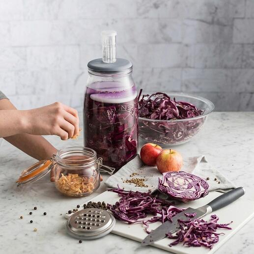 Bocal de fermentation avec soupape de gaz et légumes frais sur une table