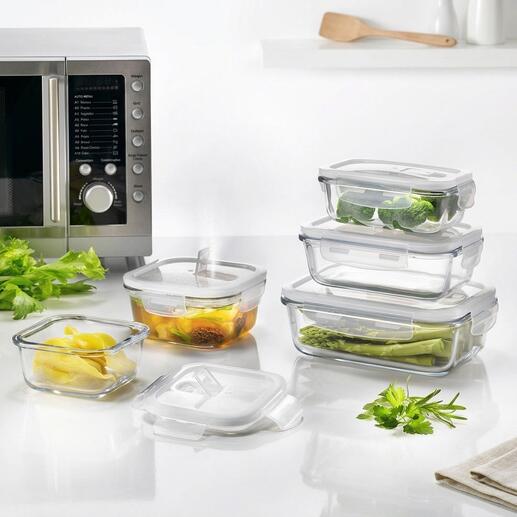Ensemble de cinq boîtes hermétiques en verre avec des légumes en arrière-plan.