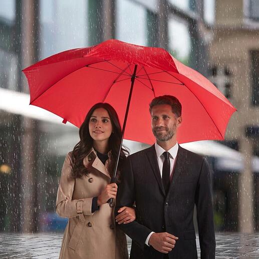 Couple sous un parapluie rouge sous la pluie.