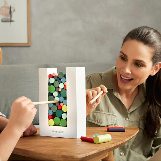 Un enfant et un adulte jouent ensemble avec le jeu de dextérité Woodman à une table.