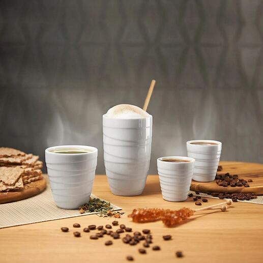 Quatre tasses thermiques en porcelaine sur une table, entourées de collations.