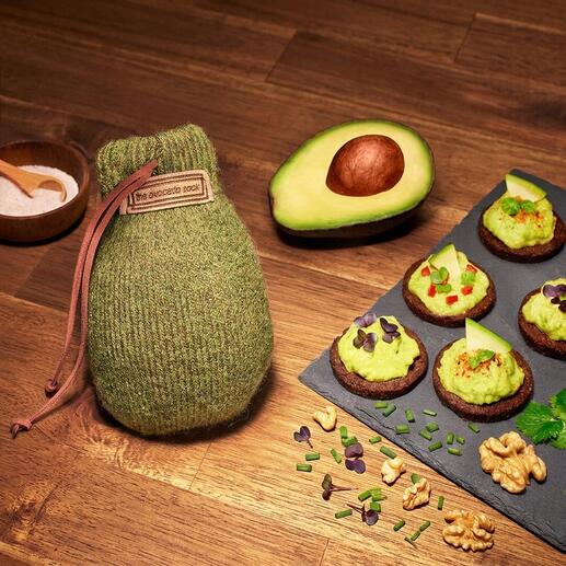 Avocado Sock® avec un avocat et des collations sur une table en bois.