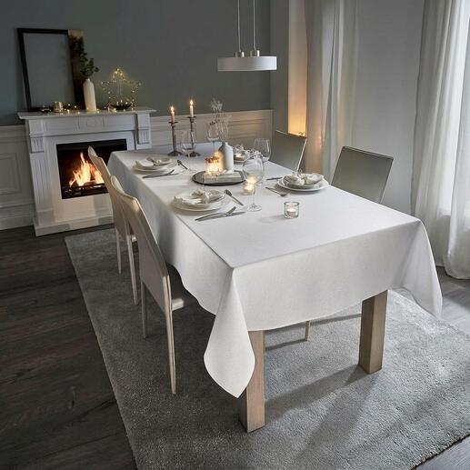 Table blanche avec nappe festive en aspect lin et bougies.
