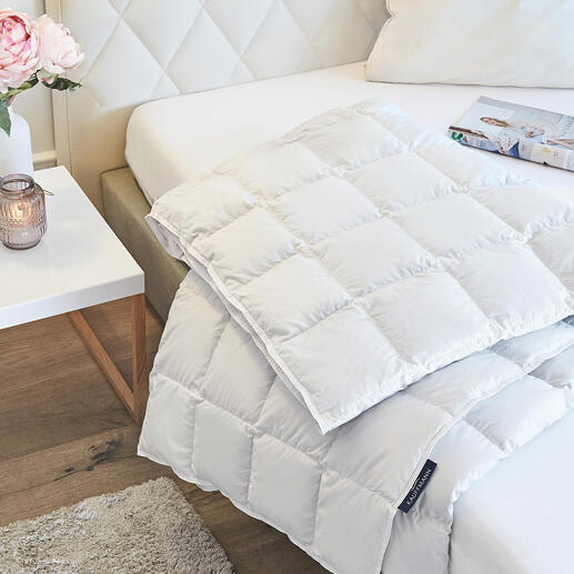 Couette légère en duvet d'eider sur un lit avec des coussins
